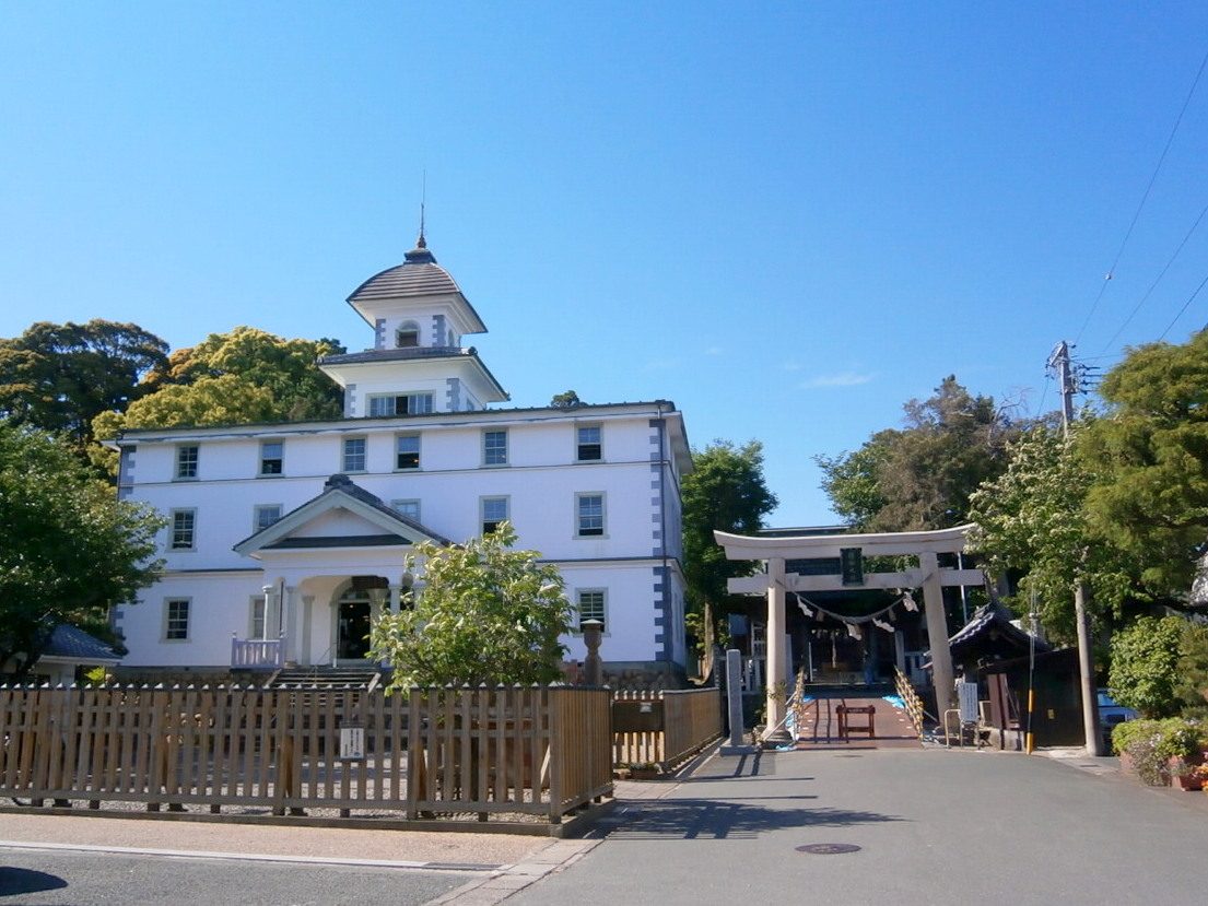 青空の下に建つ旧見付学校と、隣接する淡海國玉神社の鳥居